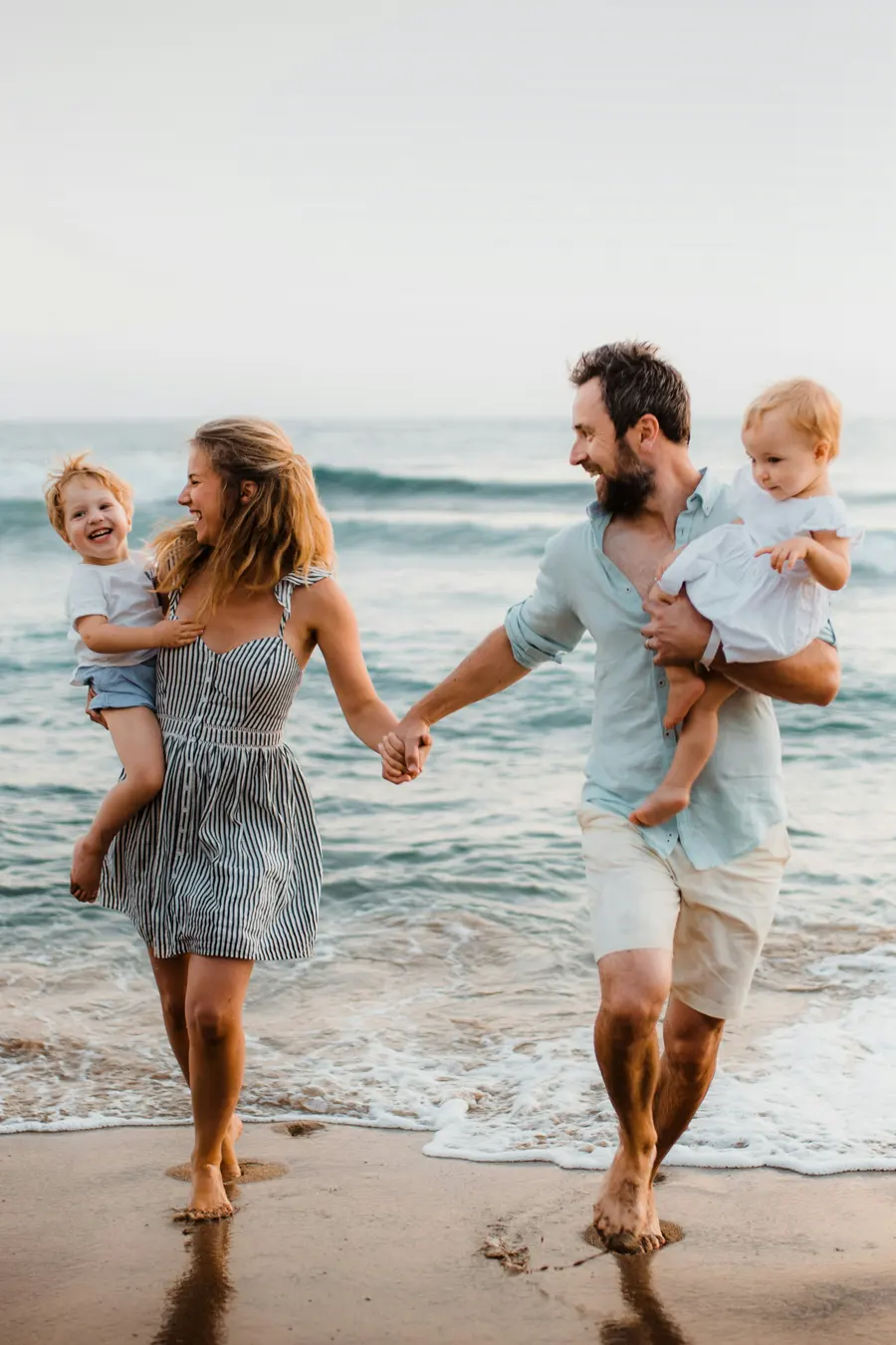 couple-with-kids-walking-beach